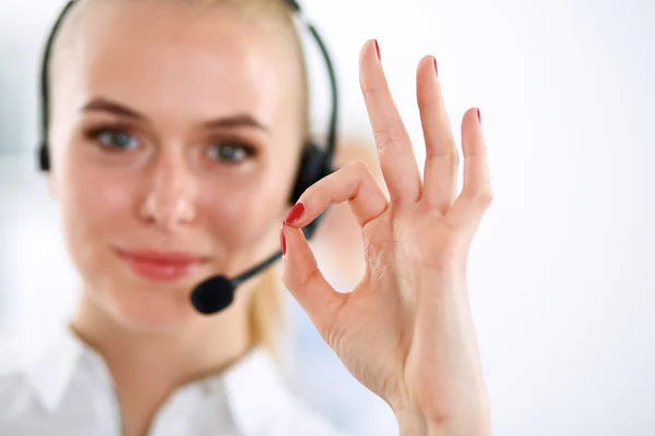 Glimlachend klant dienst meisje weergegeven: ok, geïsoleerd op witte achtergrond. — Stockfoto