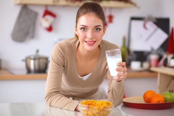 Mujer atractiva sonriente desayunando en el interior de la cocina —  Fotos de Stock