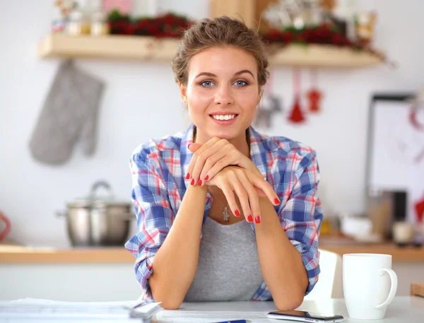 Usmívající se mladá žena v kuchyni, izolované na vánoční pozadí — Stock fotografie