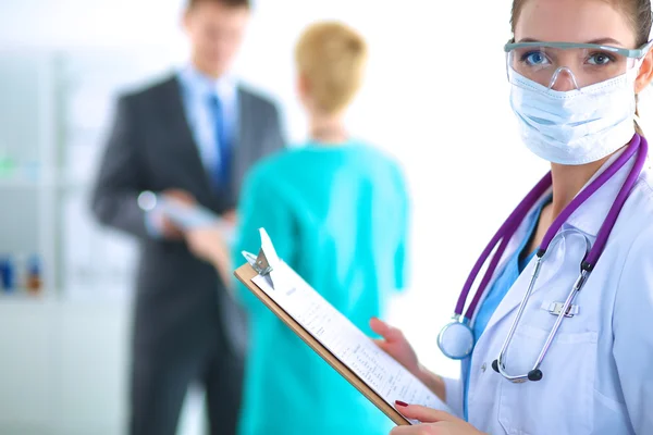 Woman doctor standing with folder at hospital — Stock Photo, Image