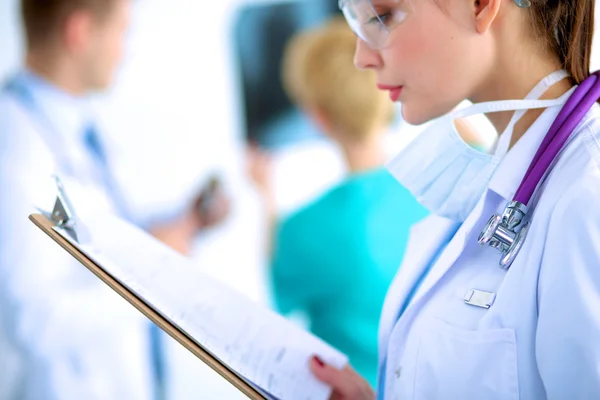 Woman doctor standing with folder at hospital — Stock Photo, Image