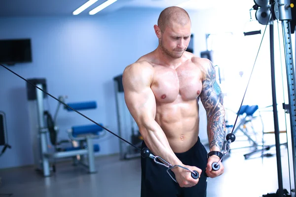 Hombre joven entrenando en el gimnasio con ejercicios — Foto de Stock