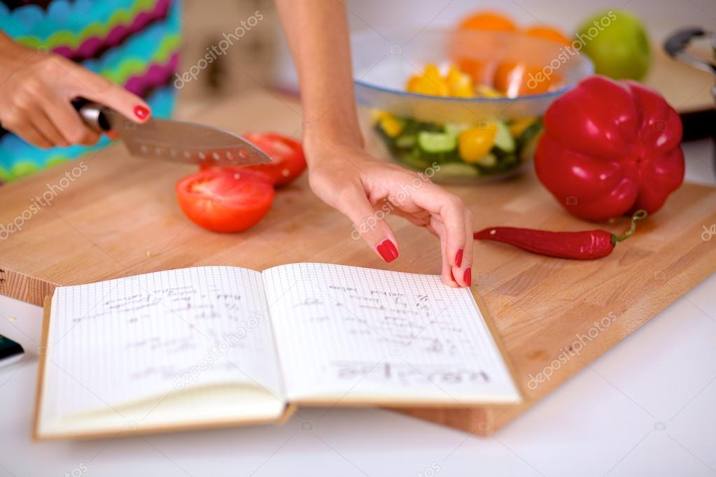 Young woman cutting vegetables in kitchen