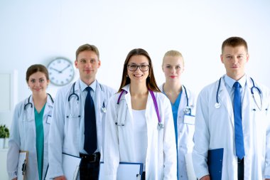 Birlikte ayakta duran bir grup gülümseyen hastane arkadaşının portresi.