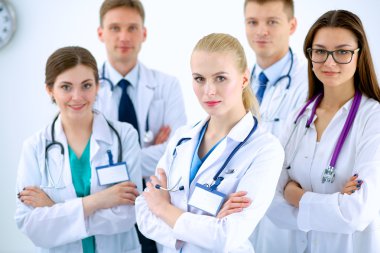 Birlikte ayakta duran bir grup gülümseyen hastane arkadaşının portresi.