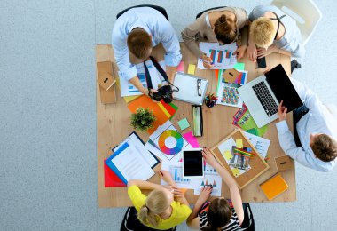İş adamları iş toplantısında, ofiste oturup tartışıyorlar.