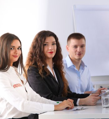 İş adamları iş toplantısında, ofiste oturup tartışıyorlar.