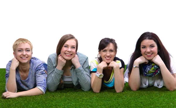 Cuatro mujeres jóvenes tumbadas sobre hierba verde — Foto de Stock