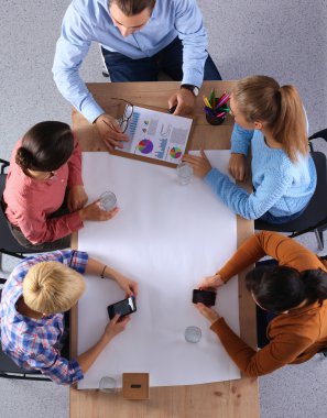 İş adamları iş toplantısında, ofiste oturup tartışıyorlar.