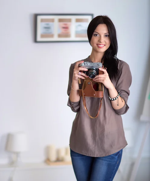 Kvinna sitter på en soffa i hennes hus med kamera — Stockfoto