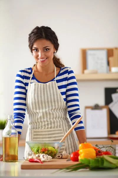 Jonge vrouw mengt verse salade — Stockfoto