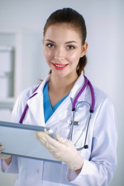 Kadın doktor hastanede dosyayla bekliyor. 