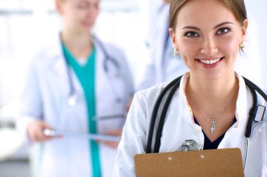 Attractive female doctor  with folder in front of medical group clipart