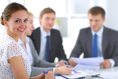 İş adamları iş toplantısında, ofiste oturup tartışıyorlar.