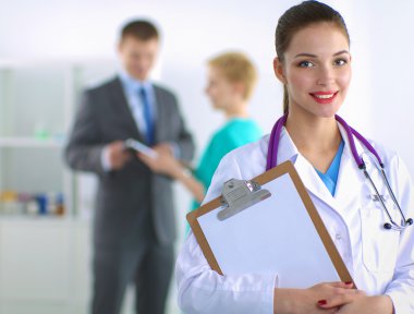 Kadın doktor hastanede dosyayla bekliyor. 