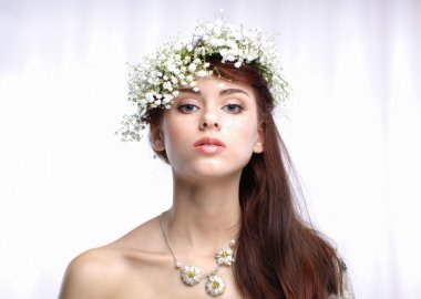 Saçında çiçekler olan güzel bir kadının portresi.