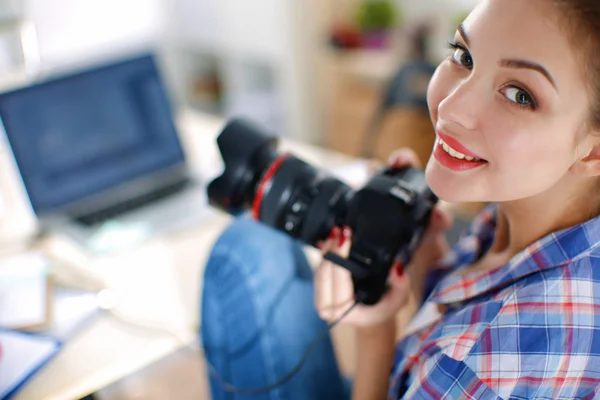 Kvinnlig fotograf sitter på skrivbordet med bärbar dator — Stockfoto