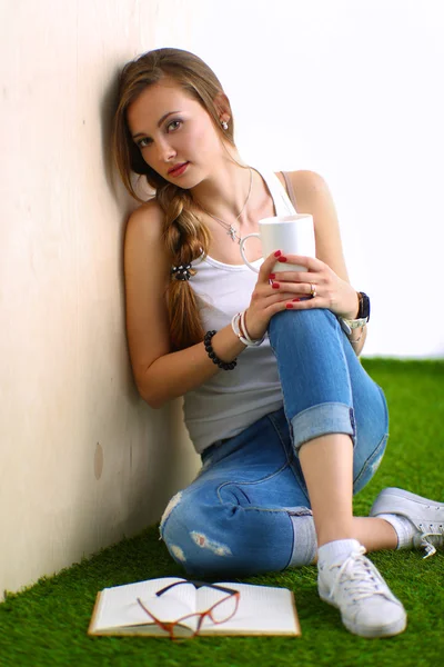 Jonge vrouw zitten met boek op gras — Stockfoto