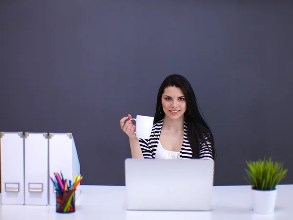 Hermosa mujer de negocios que trabaja en su escritorio con auriculares y portátil — Foto de Stock