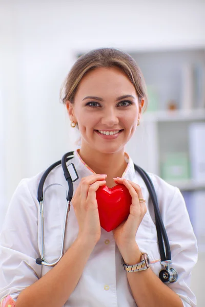 Доктор со стетоскопом держит сердце, изолированное на белом фоне — стоковое фото