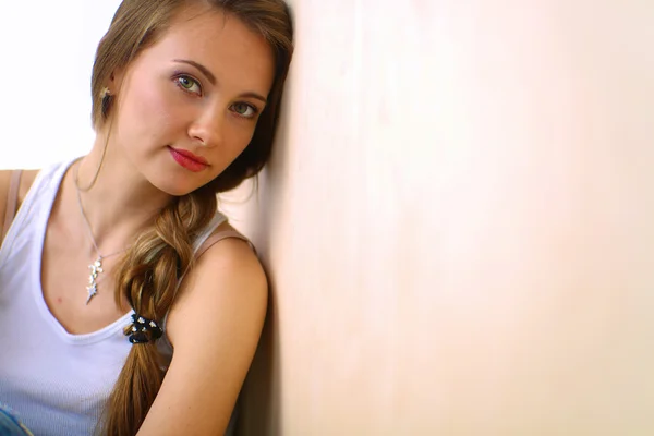 Young woman sitting on the floor near wall — Stock Photo, Image