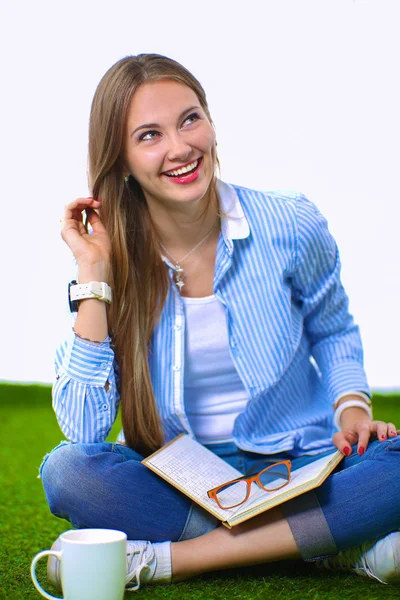 Jonge vrouw zitten met boek op gras — Stockfoto