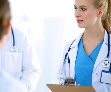 Kadın doktor hastanede dosyayla bekliyor. 