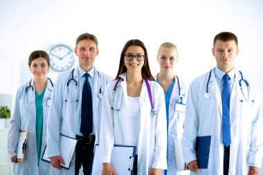 Birlikte ayakta duran bir grup gülümseyen hastane arkadaşının portresi.