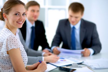 İş adamları iş toplantısında, ofiste oturup tartışıyorlar.