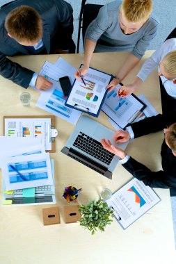 İş adamları iş toplantısında, ofiste oturup tartışıyorlar.