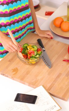 Genç kadın taze salata hazırlıyor.