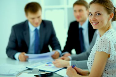 İş adamları iş toplantısında, ofiste oturup tartışıyorlar.