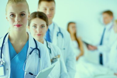 Birlikte ayakta duran bir grup gülümseyen hastane arkadaşının portresi.