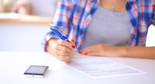 Beautiful young woman writing something in her note pad