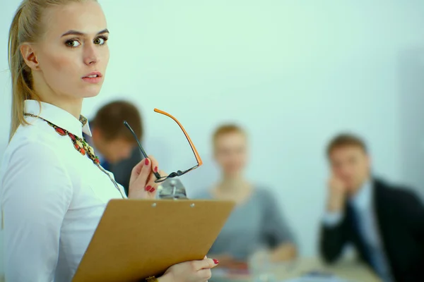 Porträt einer jungen Frau im Büro, die mit einem Ordner steht — Stockfoto