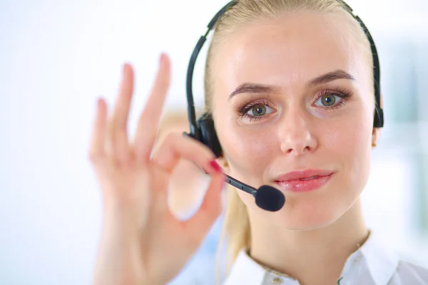 Smiling customer service girl showing ok, isolated on white background. Stock Picture