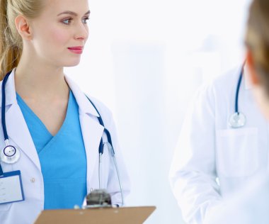 Kadın doktor hastanede dosyayla bekliyor. 