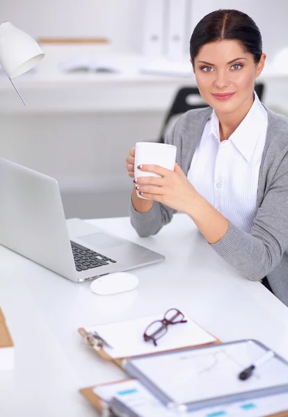 Attraktiv affärskvinna sitter på skrivbordet på kontoret — Stockfoto