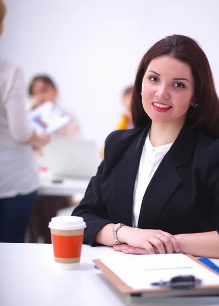 Jolie femme d'affaires assise sur le bureau avec une tasse de café — Photo