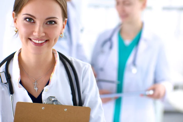 Привлекательная женщина-врач с папкой перед медицинской группой — стоковое фото