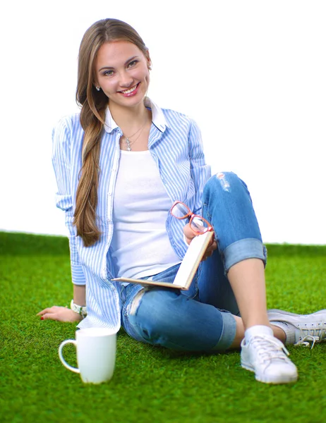 Çimenlerin üzerinde kitapla oturan genç kadın — Stok fotoğraf