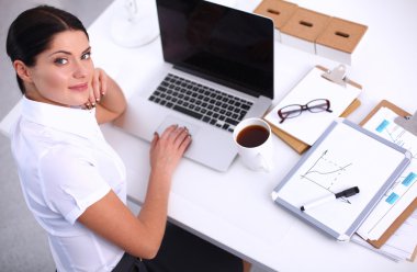 Ofiste masa başında oturan çekici bir iş kadını.