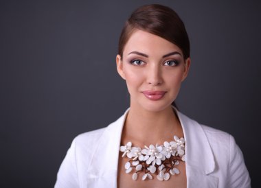 Boncuklar, gri arka plan üzerinde duran genç kadın portresi