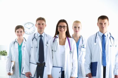 Birlikte ayakta duran bir grup gülümseyen hastane arkadaşının portresi.