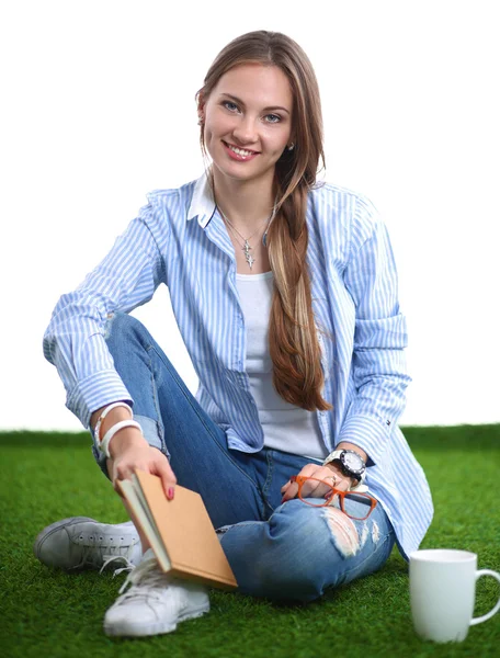 Jonge vrouw zitten met boek op gras — Stockfoto