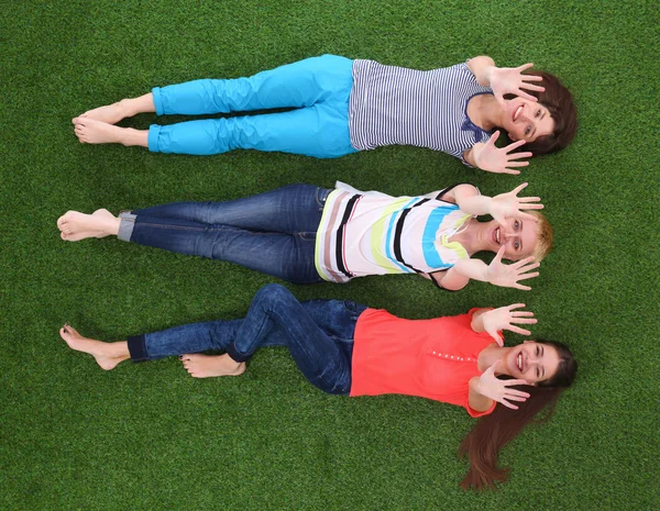 Young women lying on green grass — Stock Photo, Image