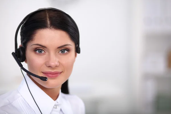 Porträtt av vacker affärskvinna arbetar på hennes skrivbord med headset och laptop — Stockfoto