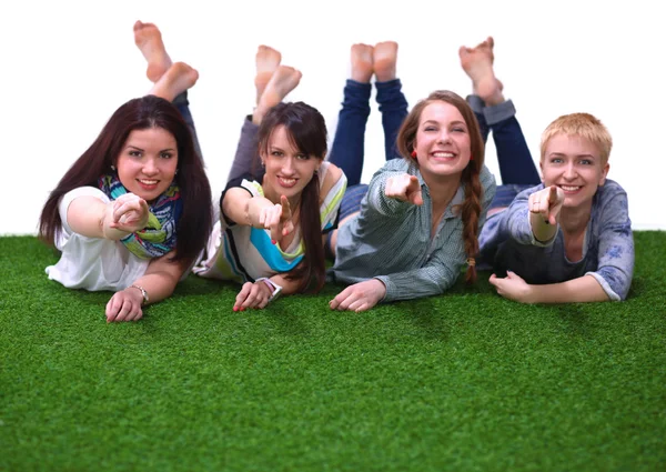 Four young women lying on green grass — Stock Photo, Image