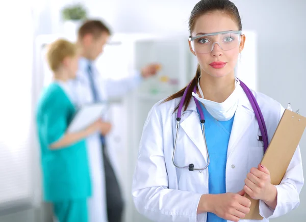 Woman doctor standing with folder at hospital — Stock Photo, Image