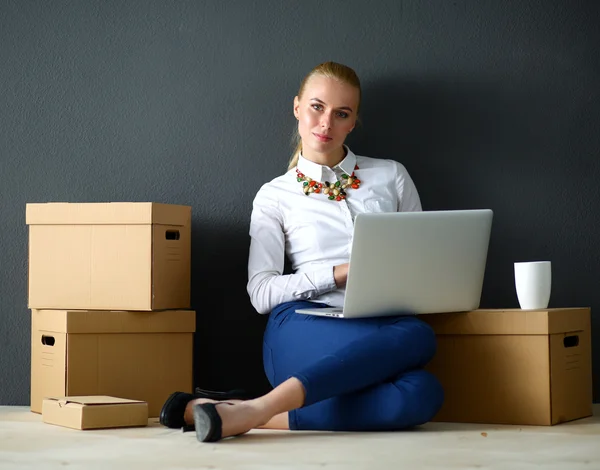 Mujer sentada en el suelo cerca de una caja con portátil —  Fotos de Stock